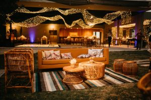Warm outdoor seating with wicker furniture and ambient lighting for an elegant evening event. — Elevating Nail Services: Unde
