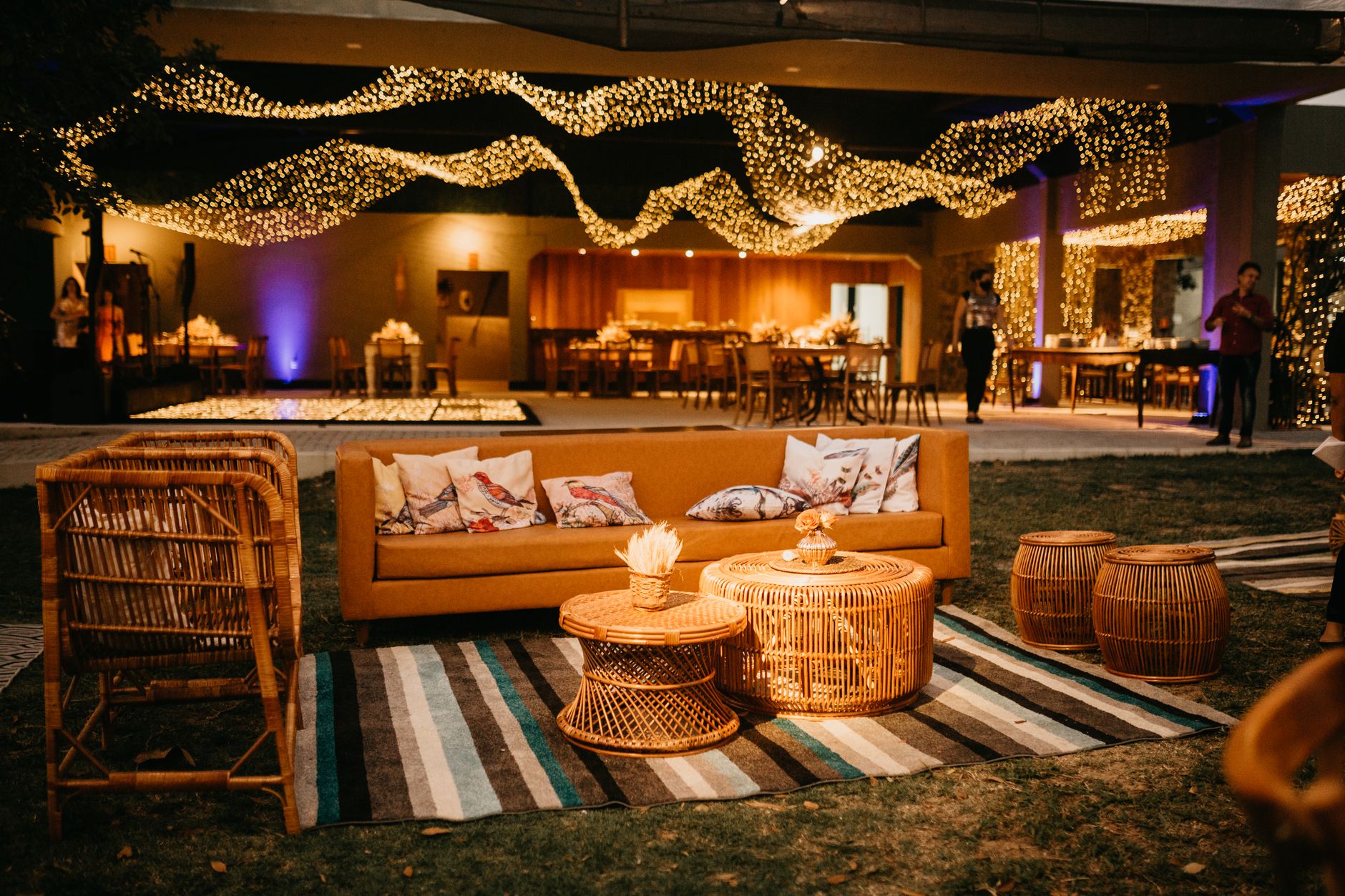 Warm outdoor seating with wicker furniture and ambient lighting for an elegant evening event. — Elevating Nail Services: Unde
